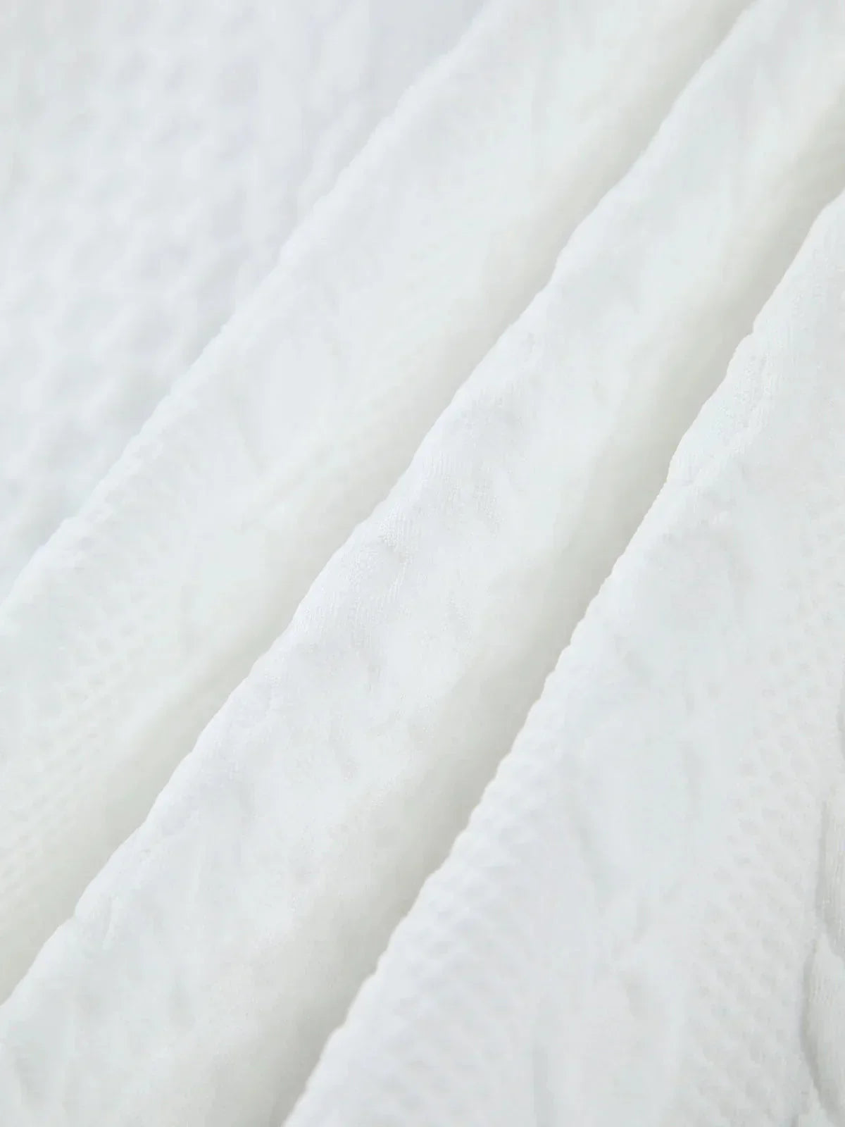 Blouse femme blanche en tissu texturé avec manches sculptées, idéale pour une allure élégante et moderne.