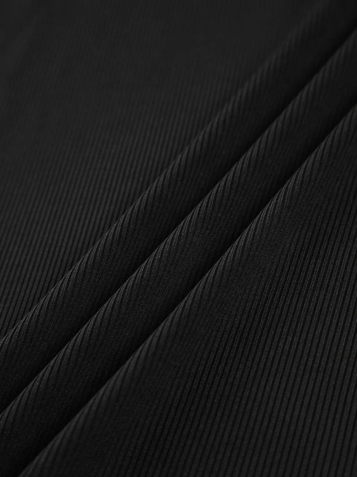 Haut femme asymétrique noir à col montant et découpe, en tissu doux et respirant.