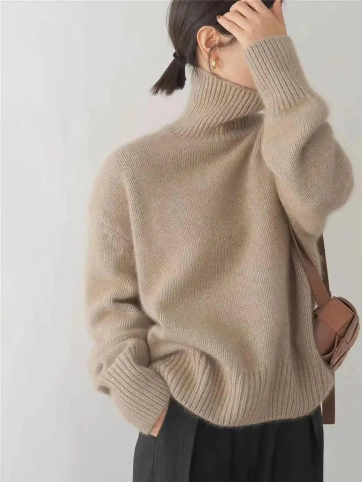 Pull à col roulé femme en tissu doux, couleur beige, adapté pour les journées fraîches et les styles variés.
