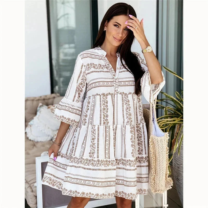 Robe courte évasée en coton, à motifs colorés, manches larges et col V, idéale pour des vacances d'été en bord de mer.