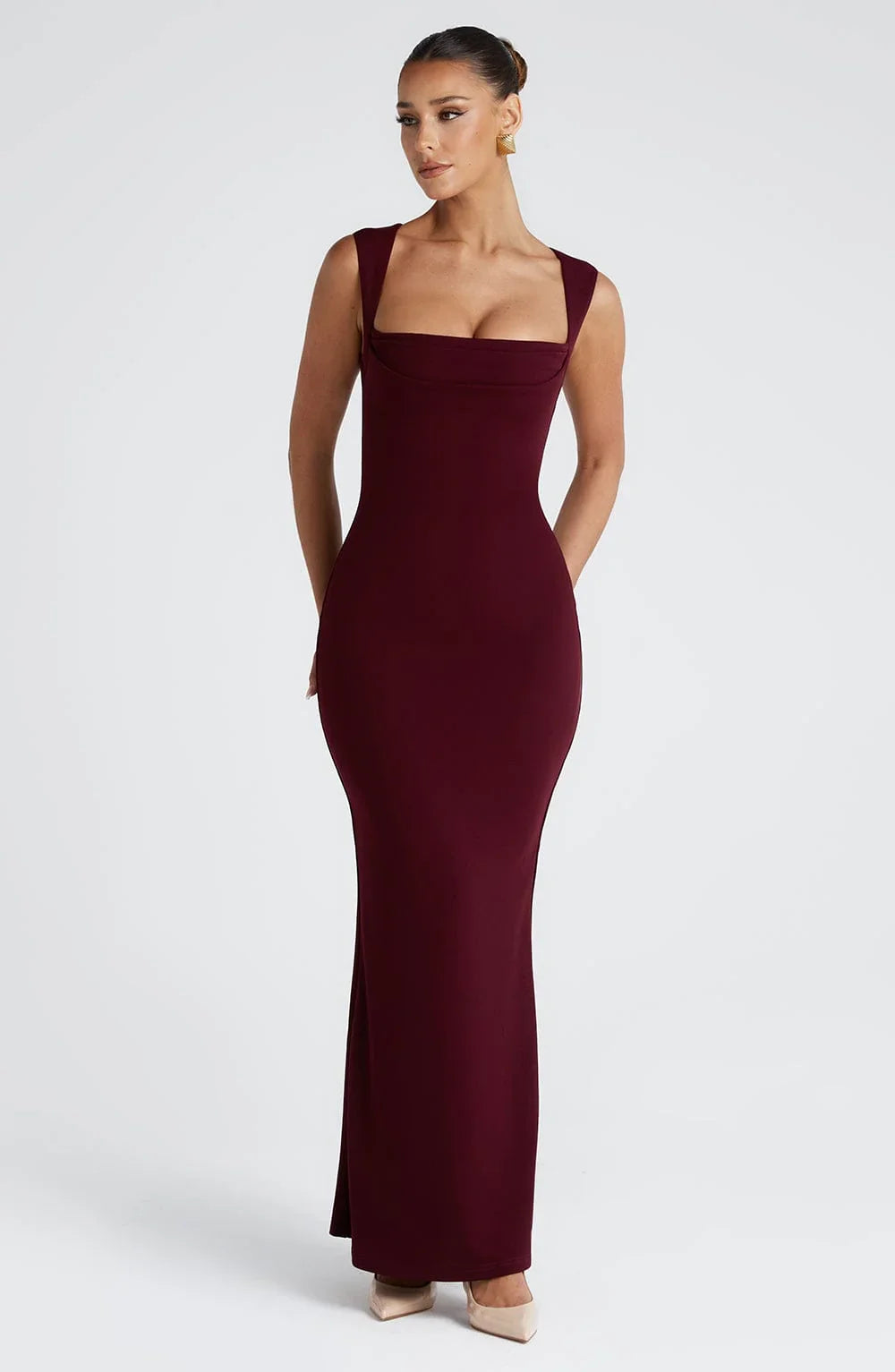 Robe longue bordeaux sans manches en tissu léger, avec une coupe fluide et des détails raffinés. Parfaite pour les soirées.