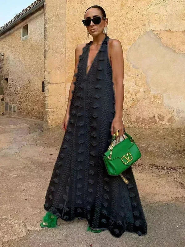 Robe longue noire avec col halter, détails floraux légers, tissu fluide et confortable pour un style élégant.