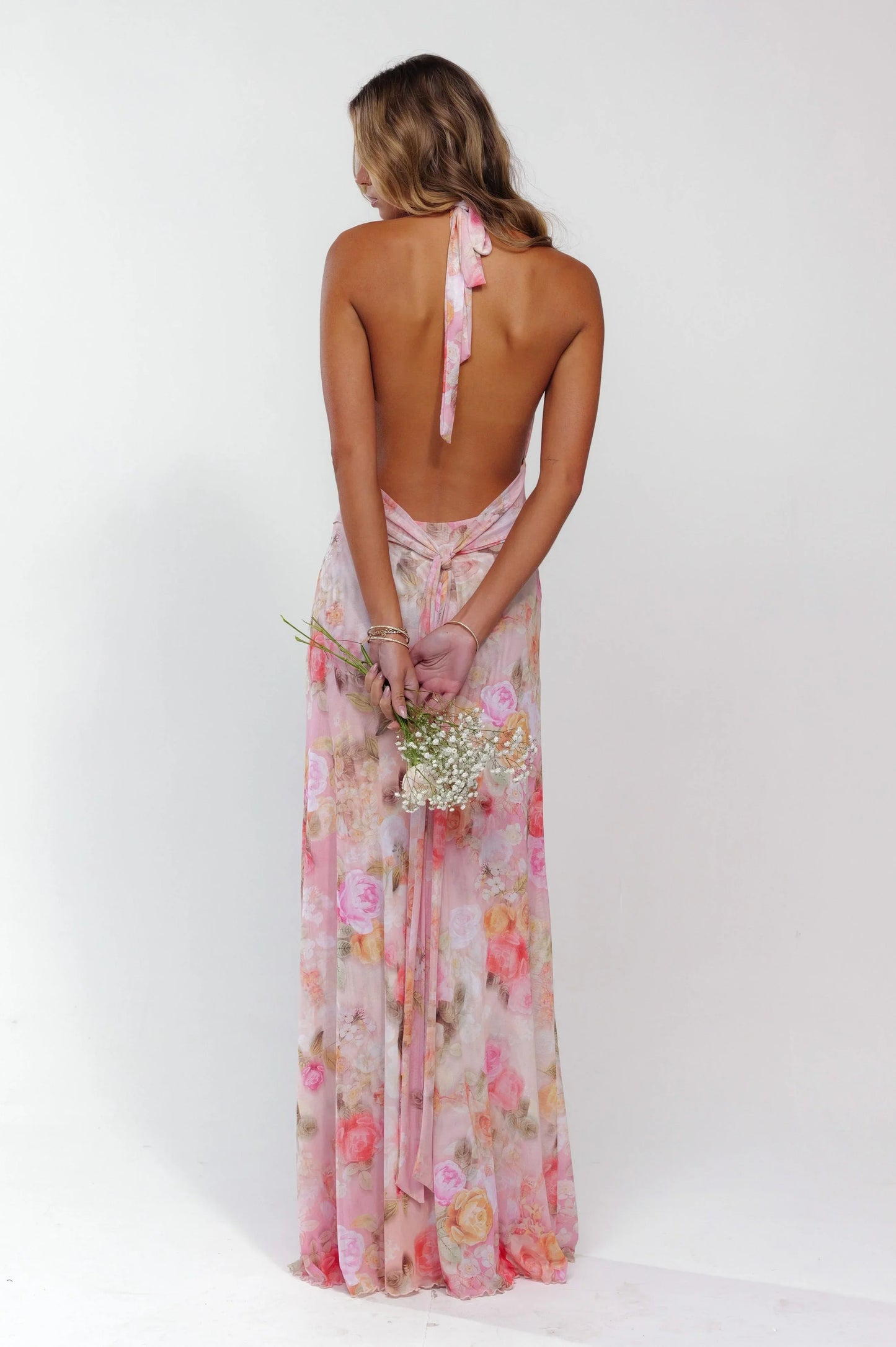 Robe longue femme rose fleurie en tissu léger, design dos nu avec motif floral, parfaite pour les journées ensoleillées.