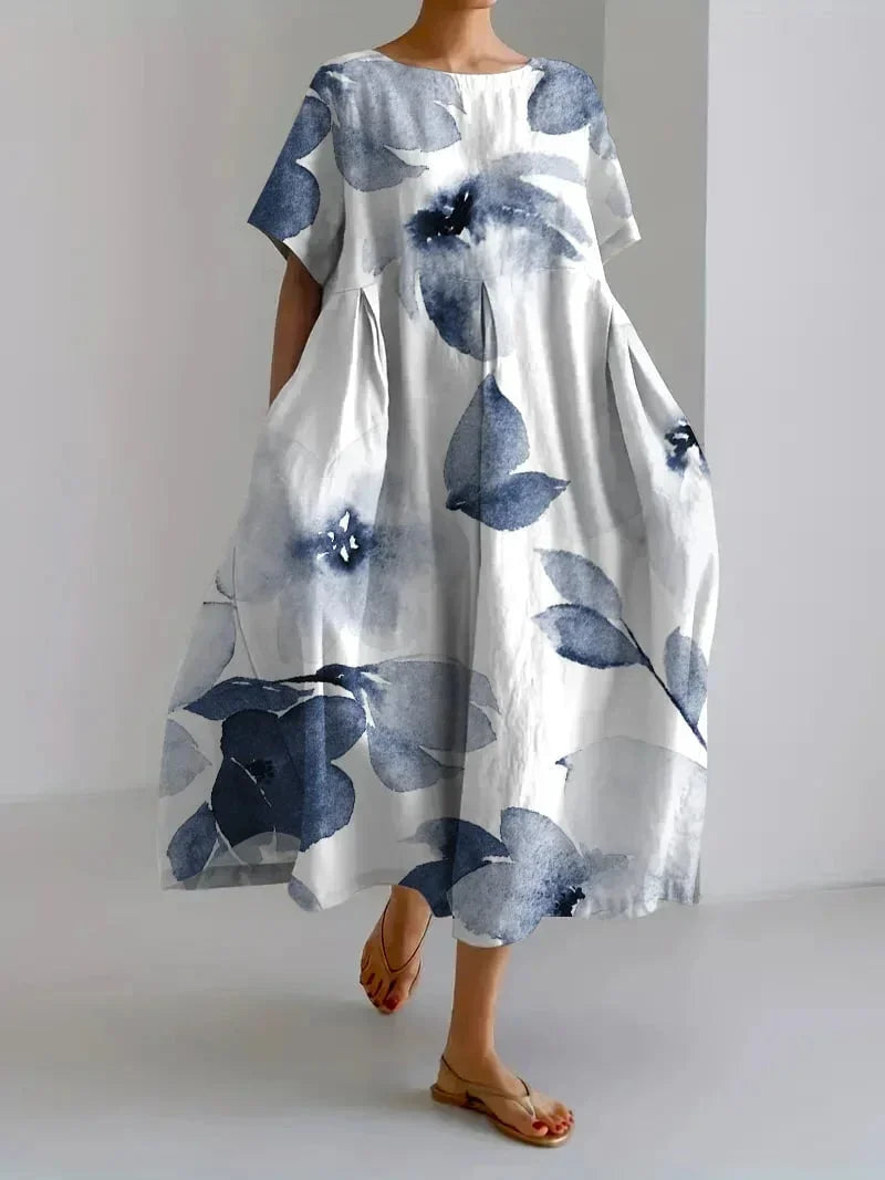 Robe maxi florale ample en fleurs indigo, manches courtes, avec poches pratiques, en tissu léger et respirant.