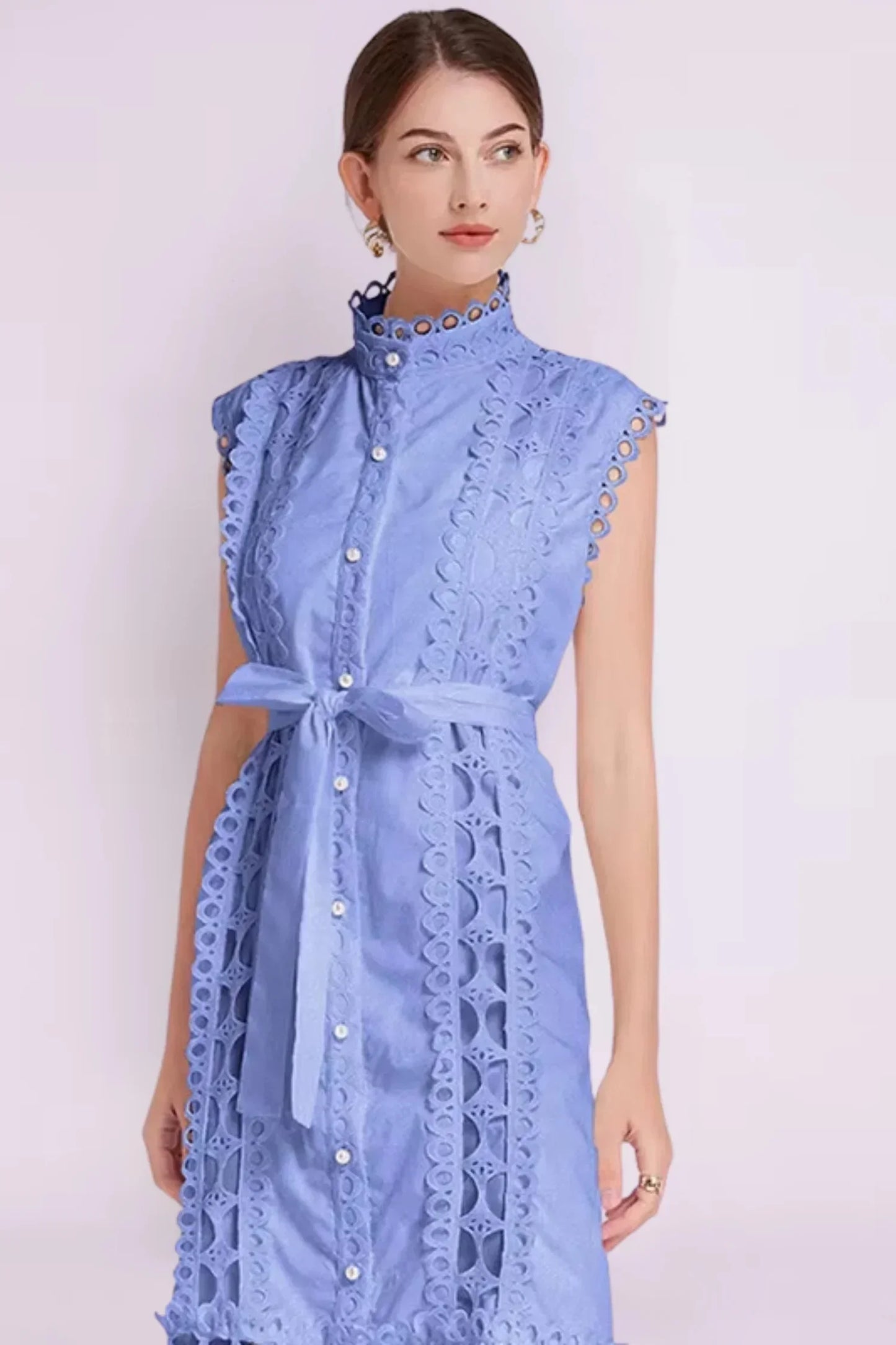 Robe midi noire sans manches en tissu léger, ornée de dentelle et accompagnée d'une ceinture pour une silhouette ajustée.