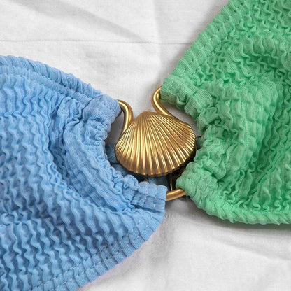 Bikini asymétrique féminin en tissu texturé, avec anneau décoratif au niveau du décolleté et taille échancrée.
