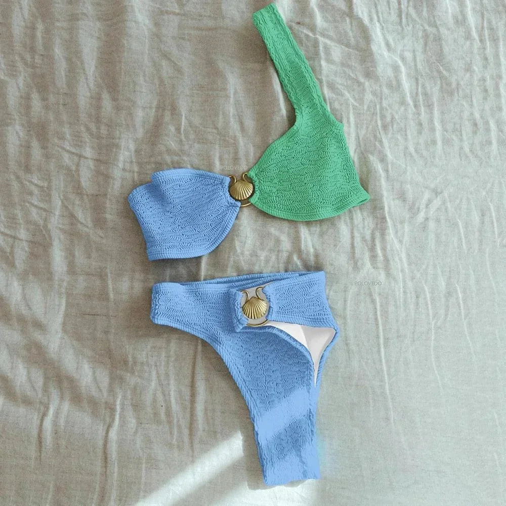 Bikini femme asymétrique en tissu texturé avec un détail anneau, offrant un style moderne et unique pour la plage.