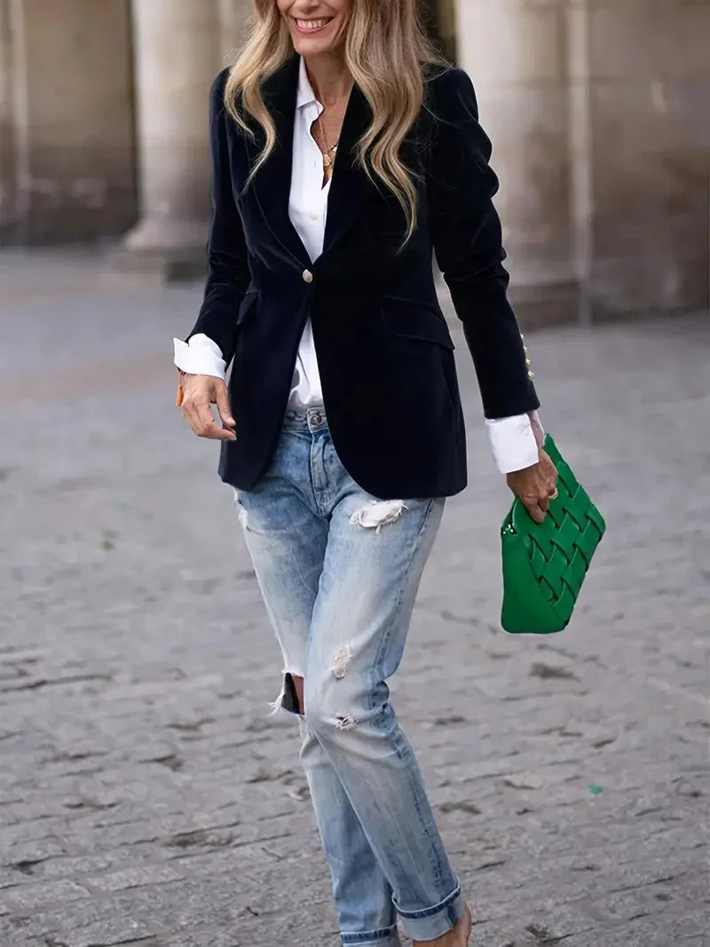 Blazer ajusté en velours noir pour femme, avec boutons décoratifs modernes et coupe cintrée.