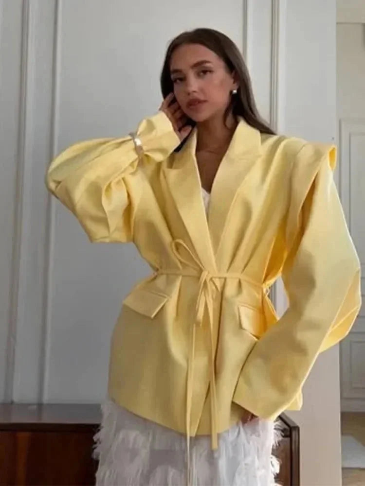 Blazer rose pour femme avec laçage, épaulettes et coupe élégante en tissu léger et respirant.