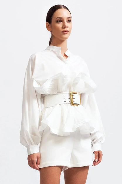 Blouse femme blanche en tissu léger, avec volants et manches volumineuses, au design élégant.