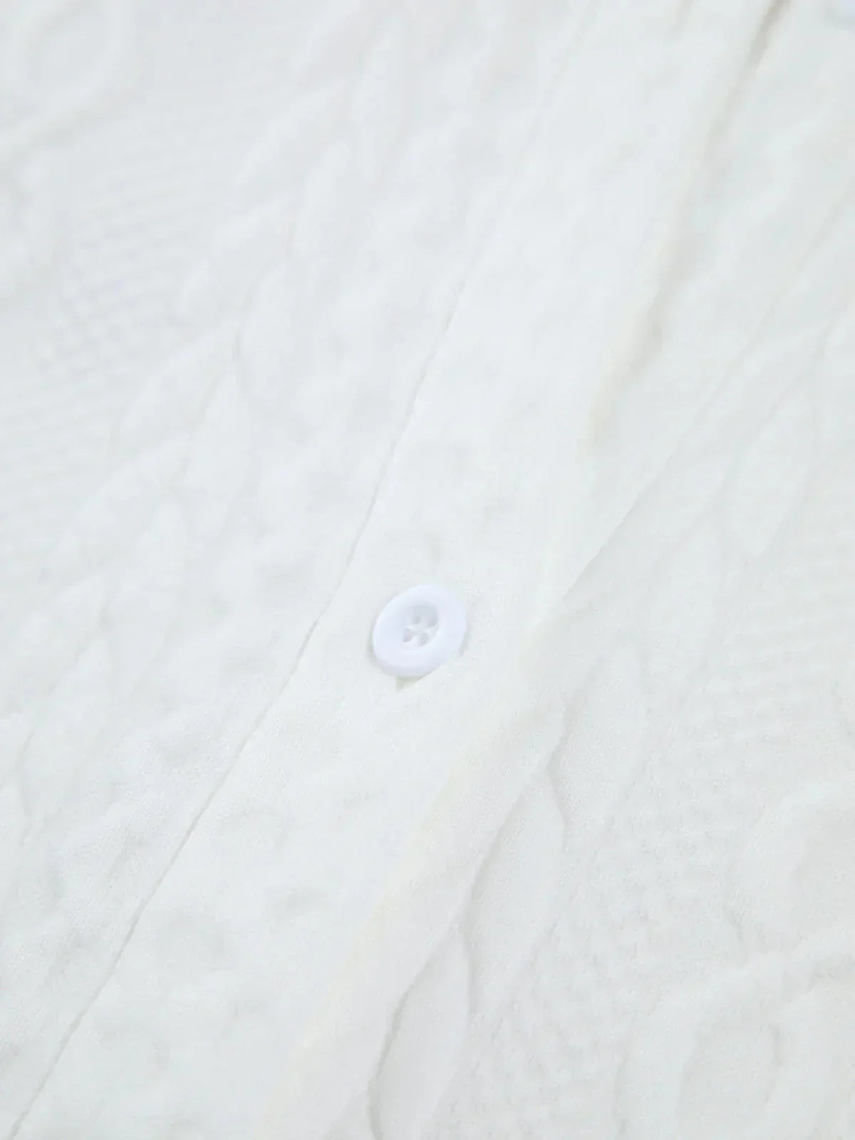 Blouse femme blanche en coton texturé, avec manches sculptées pour un style élégant et distinctif.