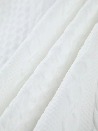 Blouse femme blanche en tissu texturé avec manches sculptées, idéale pour une allure élégante et moderne.