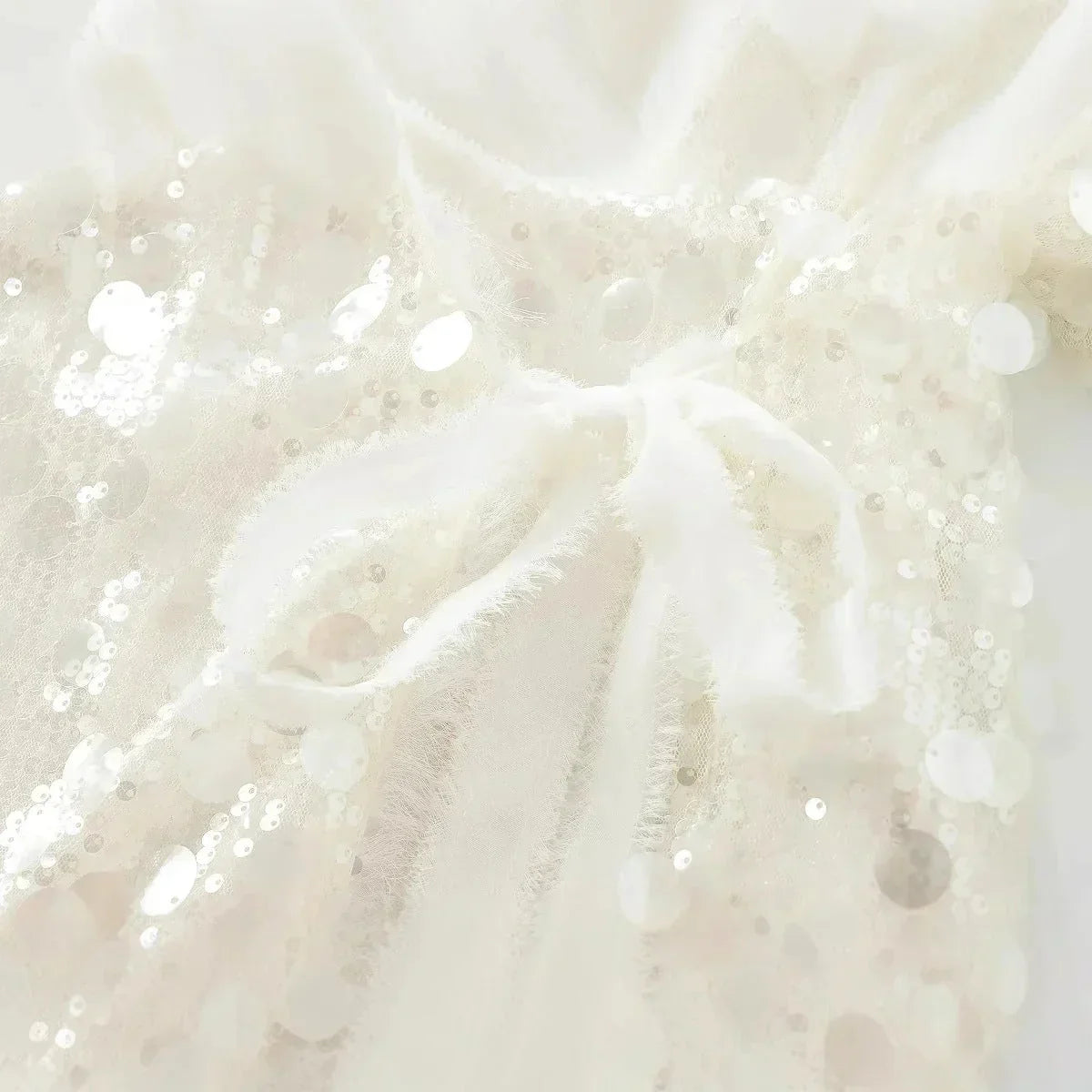Blouse femme ivoire en tissu léger, ornée de paillettes et dotée d'un col en V pour une coupe élégante et décontractée.