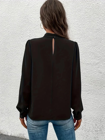 Haut noir à manches longues pour femme, coupe élégante, en tissu léger avec des détails raffinés.