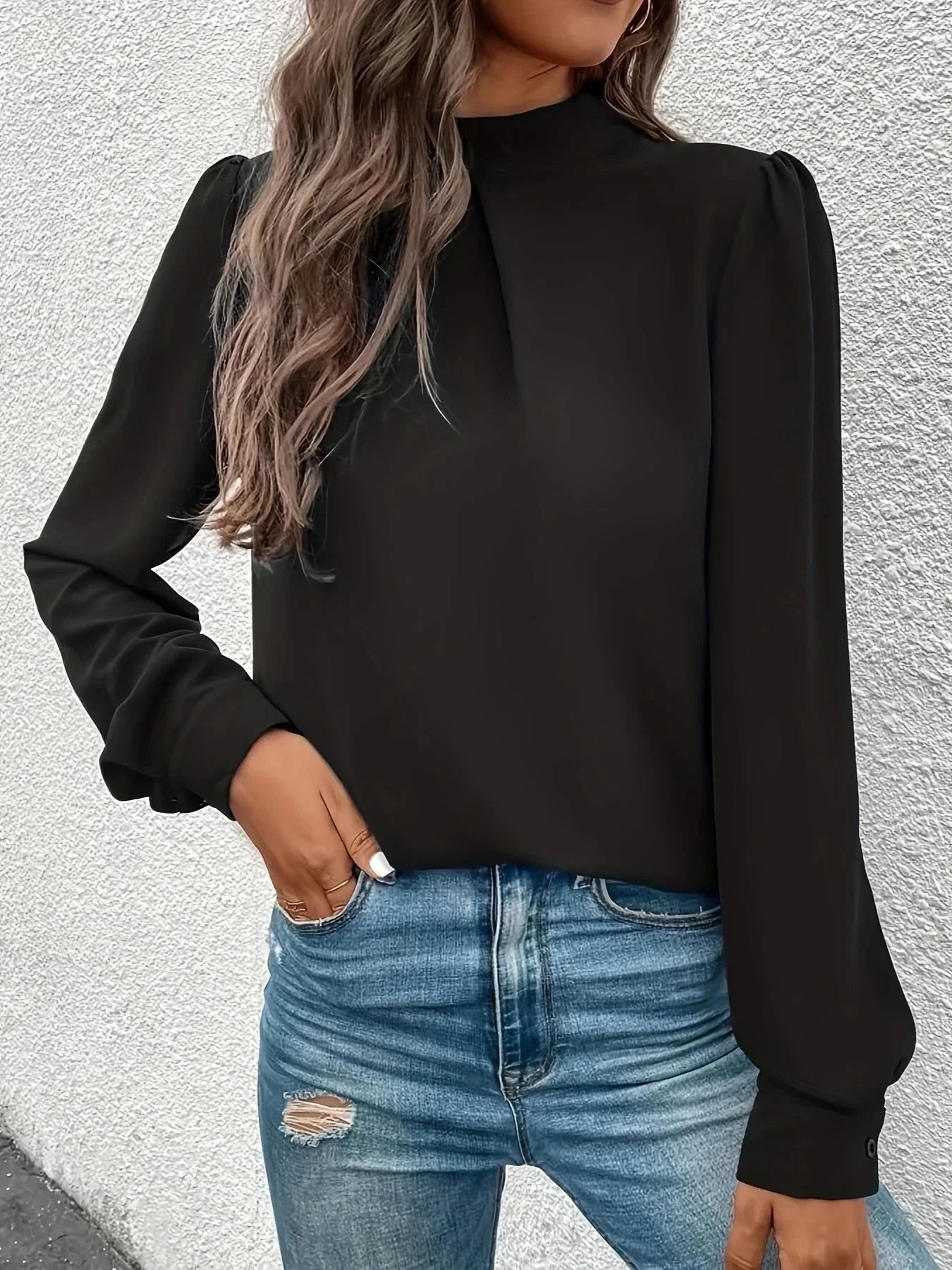 Haut noir à manches longues pour femme, coupe élégante, en tissu doux et respirant.