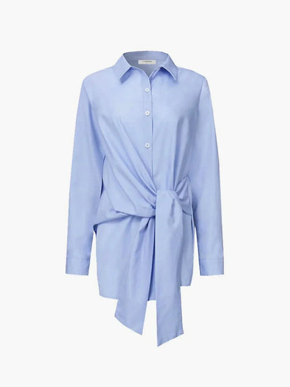 Blouse femme bleu, nouée devant, manches boutonnées, en coton léger, design élégant et décontracté pour toutes occasions.