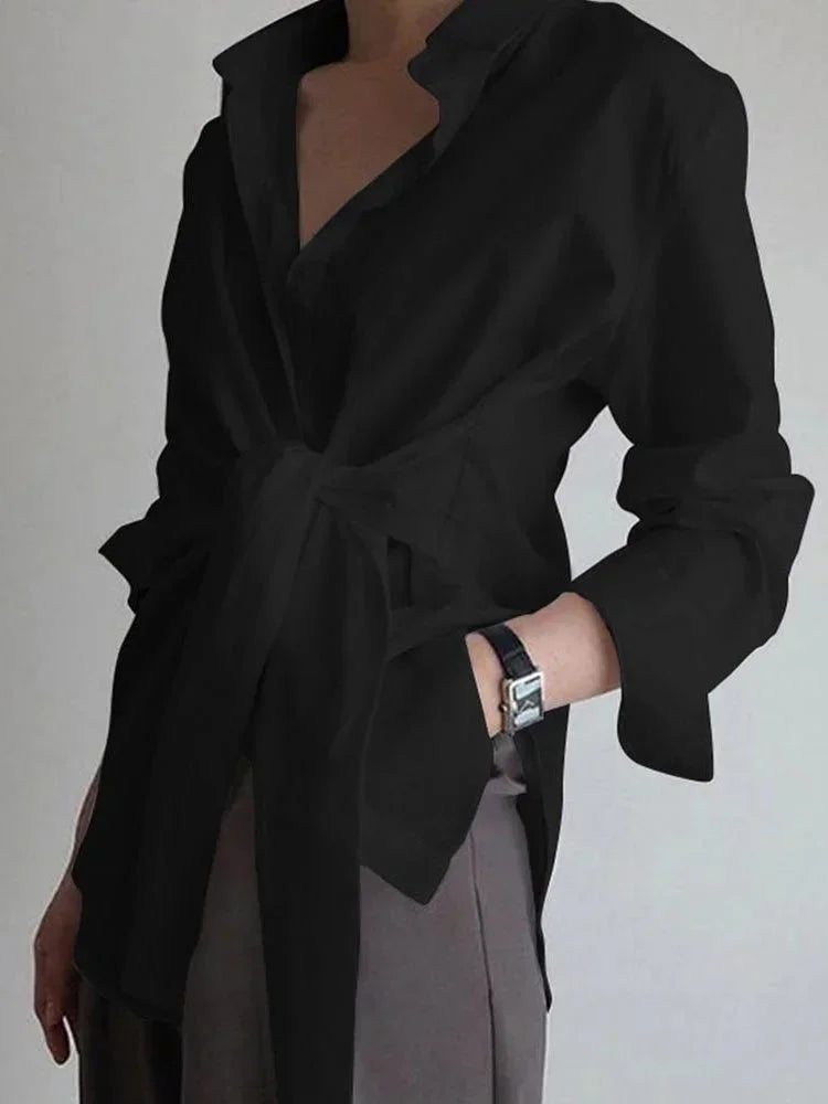 Blouse femme noire nouée devant, manches boutonnées, en tissu léger, idéale pour un style décontracté et élégant.