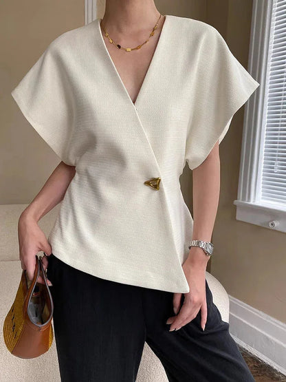 Blouse femme cache-cœur en tissu léger avec manches sculptées, offrant une coupe élégante et un confort optimal.