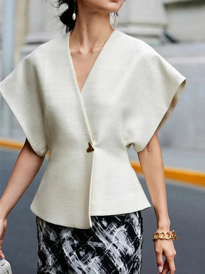 Blouse femme en tissu léger, style cache-cœur avec manches sculptées et silhouette fluide, parfaite pour un look élégant.