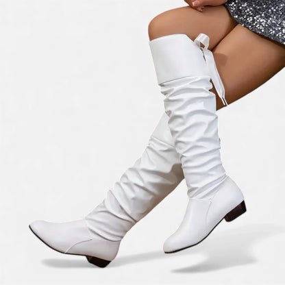 Bottes mi-hautes rouges en simili cuir, avec nœud décoratif et talon bas.