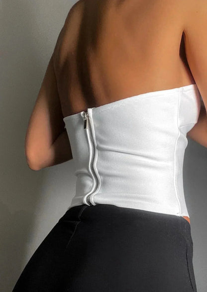 Bustier femme sans bretelles en tissu extensible, avec une découpe ondulée élégante et un fit ajusté pour le confort.