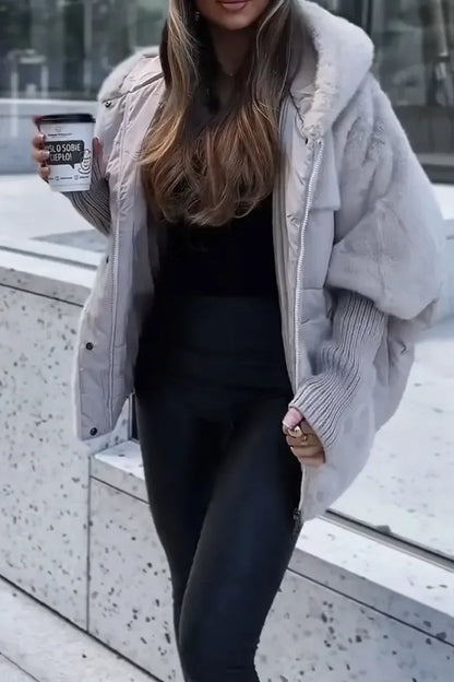 Cape d'hiver beige matelassée avec capuche et col en fausse fourrure, conçue pour les journées froides.