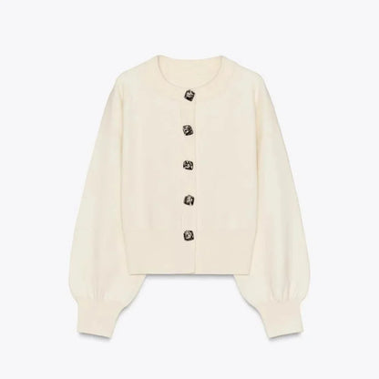 Cardigan crème pour femme, à manches longues, avec boutons décoratifs et coupe décontractée.