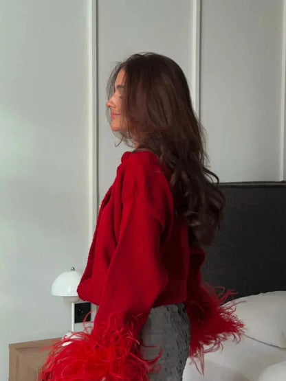 Cardigan femme rouge avec manches en plumes et boutons, en tissu doux, coupe classique.