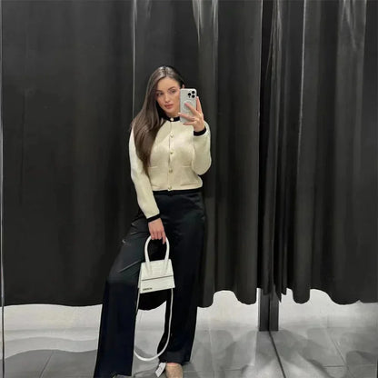 Cardigan beige pour femme en tricot avec boutons, conçu en laine douce, adapté aux saisons intermédiaires.