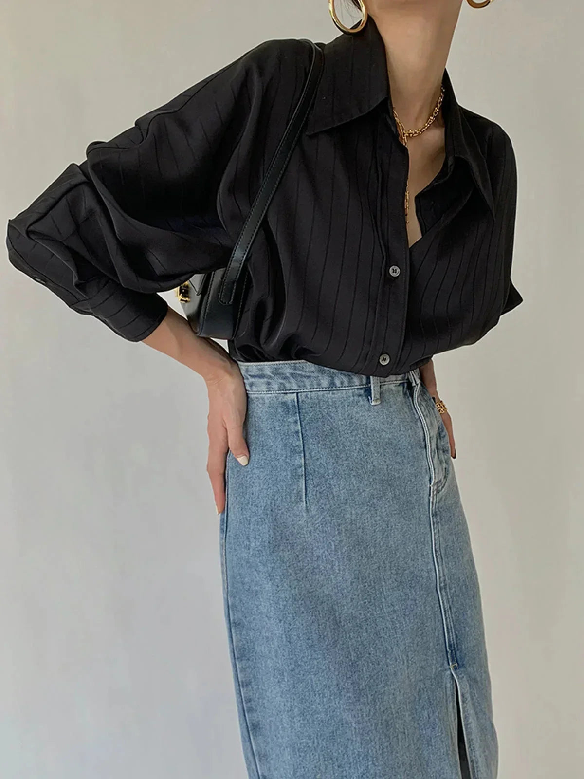 Chemise femme en tissu léger avec boutons dorés et détails raffinés, idéale pour une tenue chic et décontractée.