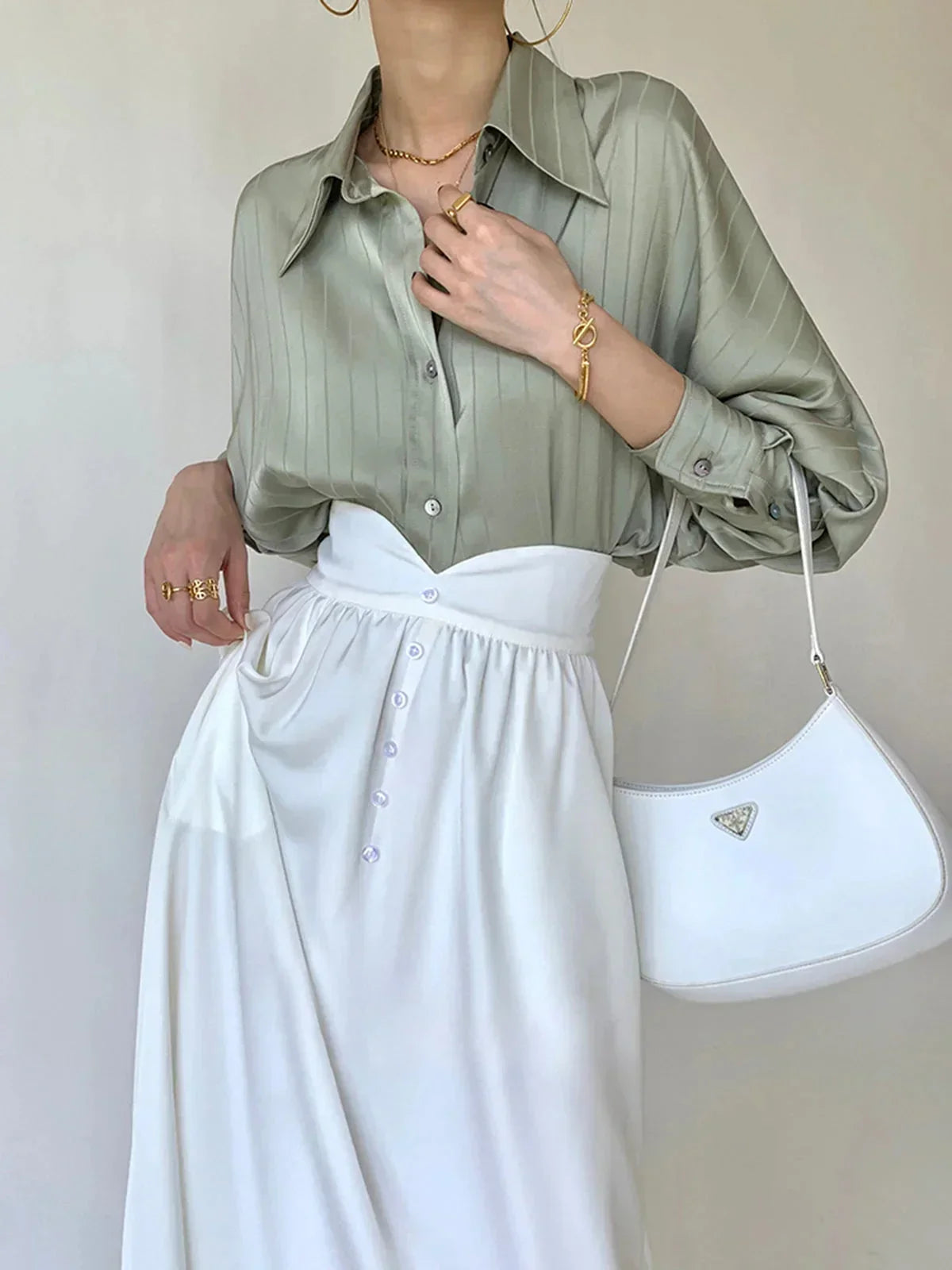 Chemise femme en tissu léger, avec boutons dorés et accents raffinés, parfaite pour un look élégant et chic.