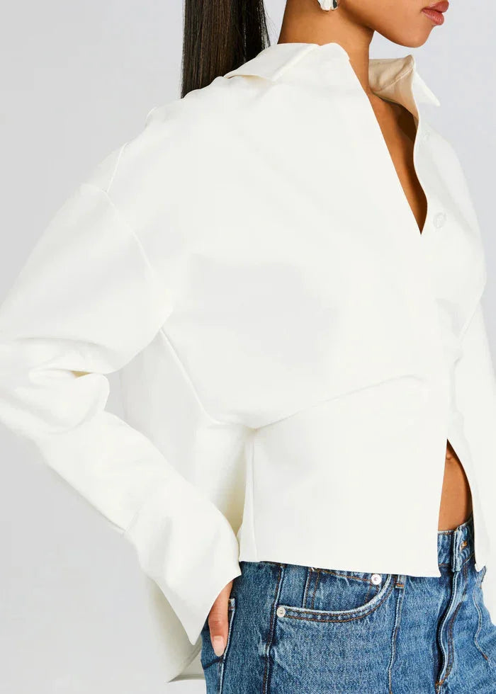 Chemise fluide blanche cassée pour femme, en mélange de coton, avec un col boutonné et une coupe décontractée.