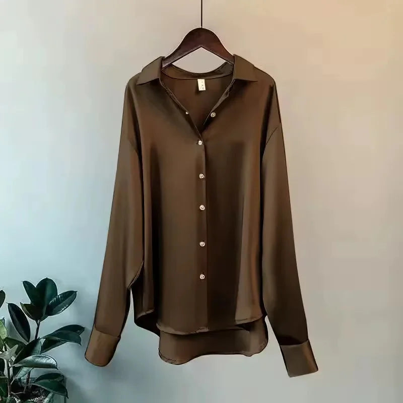 Chemisier femme en satin vert, boutonné, à manches longues, adapté pour des occasions formelles.