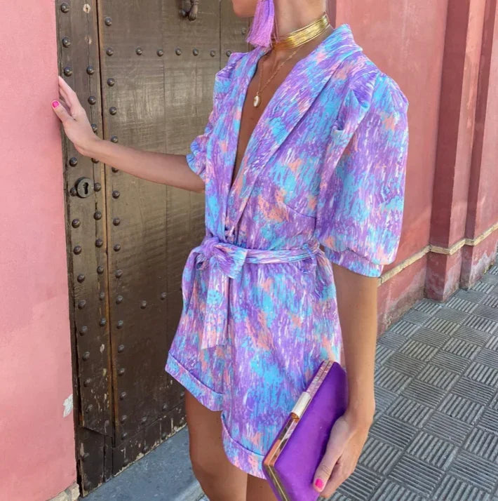 Combinaison courte femme en tissu léger, manches bouffantes, ceinture nouée pour ajustement et look élégant.