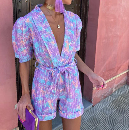 Combinaison courte femme en tissu doux, avec manches bouffantes, ceinture nouée et design élégant.