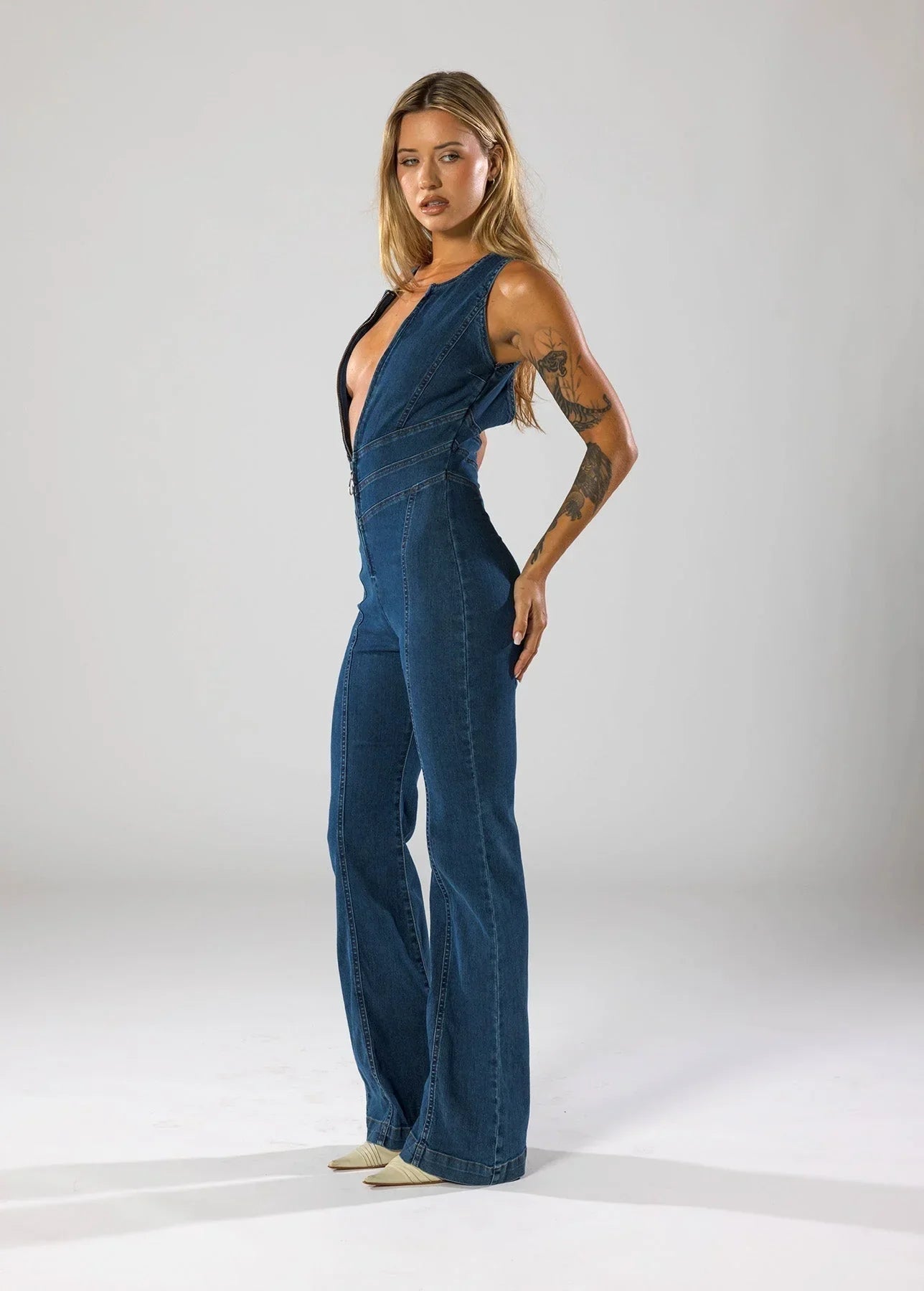 Combinaison en denim bleu marine pour femme, décolleté V profond, coupe décontractée.