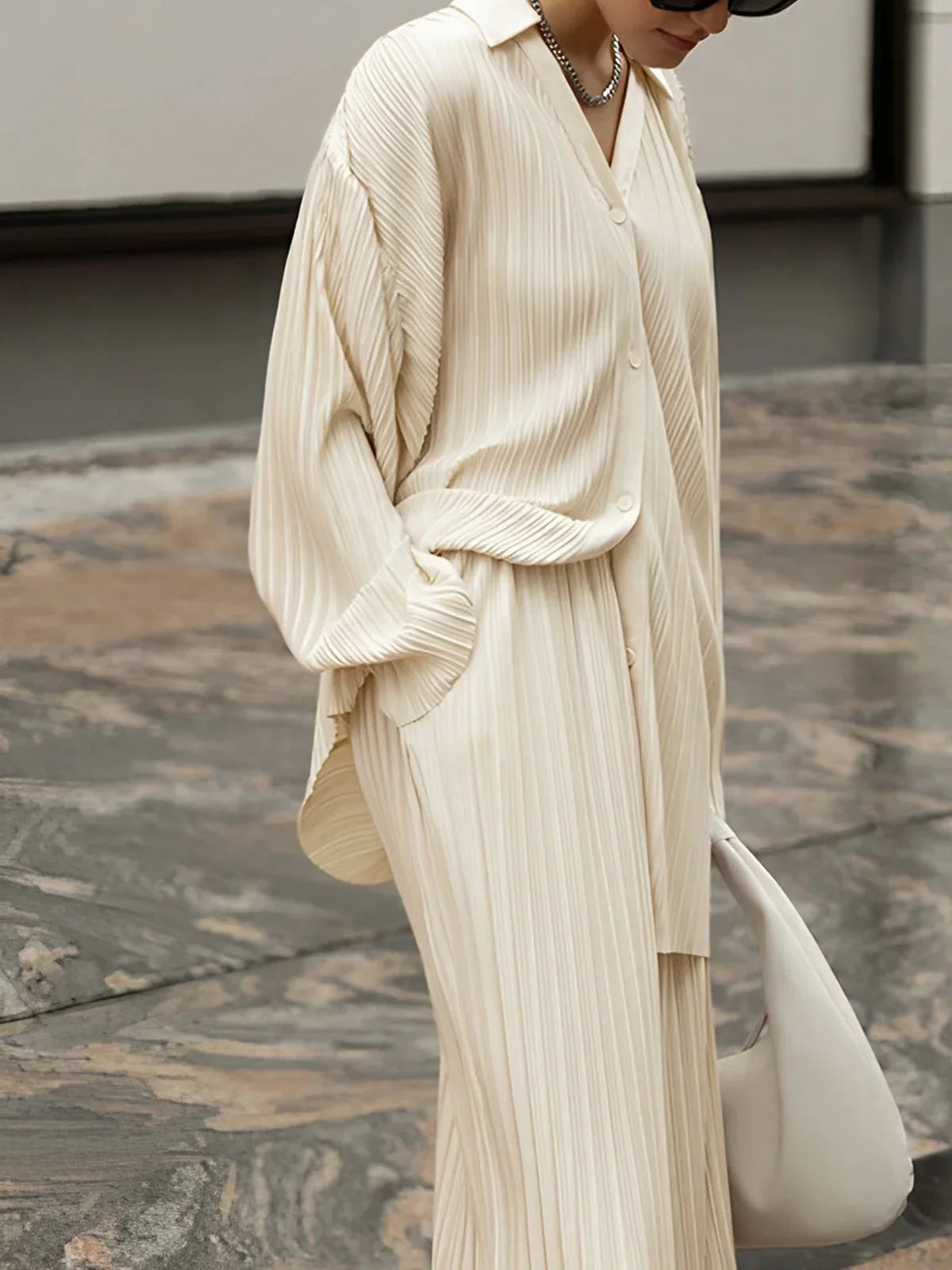 Ensemble deux pièces plissé blanc pour femme, comprenant une blouse et un pantalon à taille élastique.
