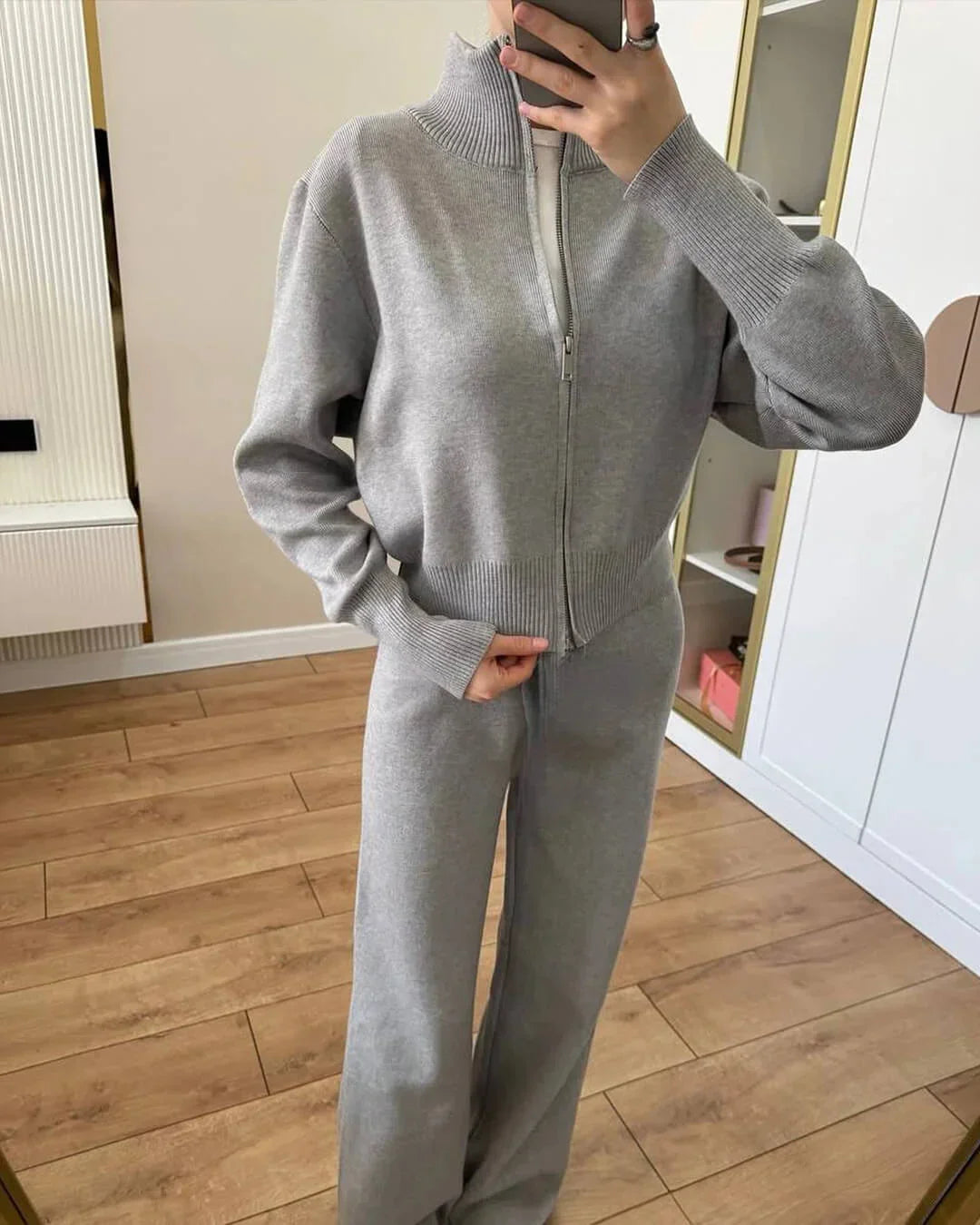 Ensemble femme gris en tricot doux, avec fermeture éclair et coupe confortable pour des moments de détente.