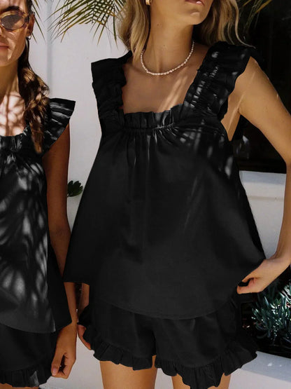 Ensemble femme noir en tissu léger, haut sans manches avec volants et short assorti, idéal pour les journées chaudes.