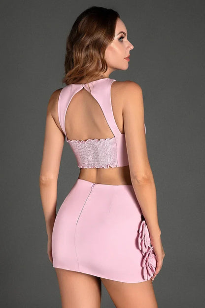 Ensemble femme rose en tissu léger, avec top dos nu et délicats appliqués floraux sur le devant.