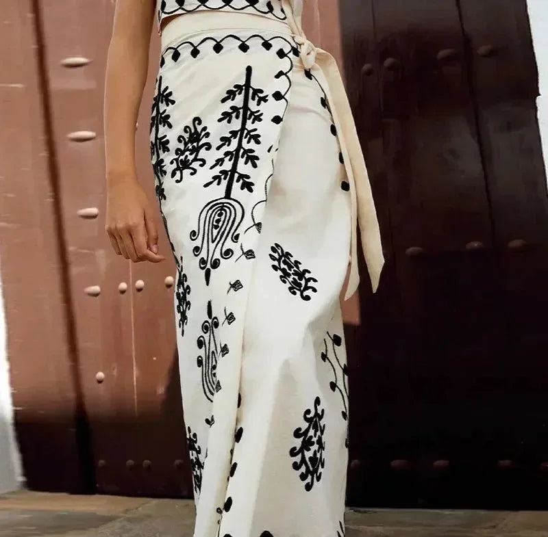 Ensemble femme sans manches en coton brodé, avec jupe fluide et détail délicat, idéal pour les journées d'été.