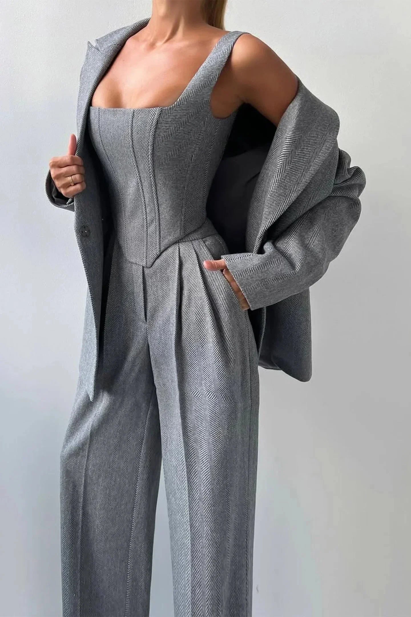 Ensemble femme trois pièces rose avec haut ajusté et coupe cintrée.