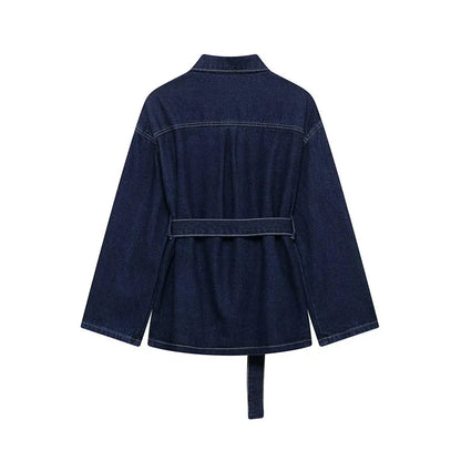 Ensemble femme en denim, comprenant une veste et un pantalon avec ceinture assortie. Style décontracté.