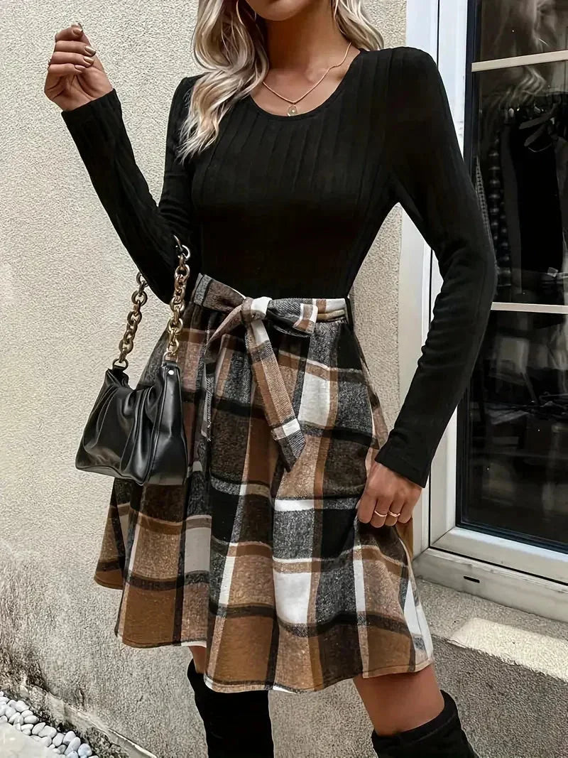 Haut ajusté noir en polyester avec manches longues, associé à une jupe évasée à carreaux en coton confortable.