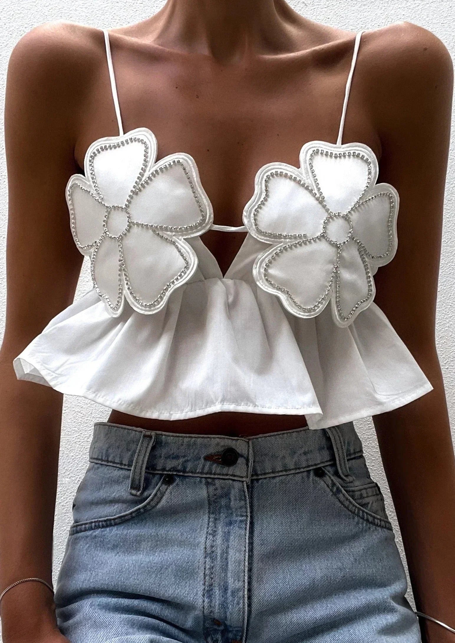 Haut court femme en coton léger, avec appliques florales et bretelles fines, parfait pour un look estival décontracté.