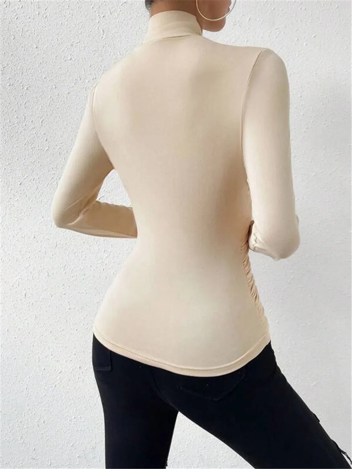 Haut croisé drapé en tissu léger, manches longues, couleur beige, adapté pour des tenues variées.