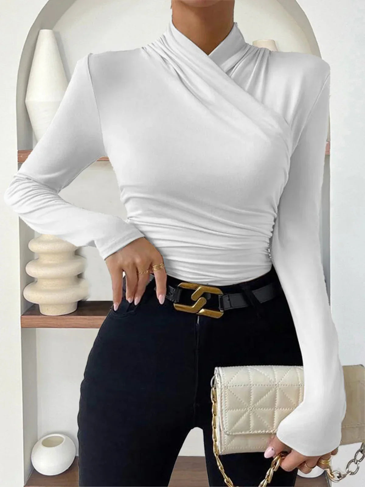 Haut noir croisé drapé à manches longues, avec un décolleté en V pour une coupe élégante.