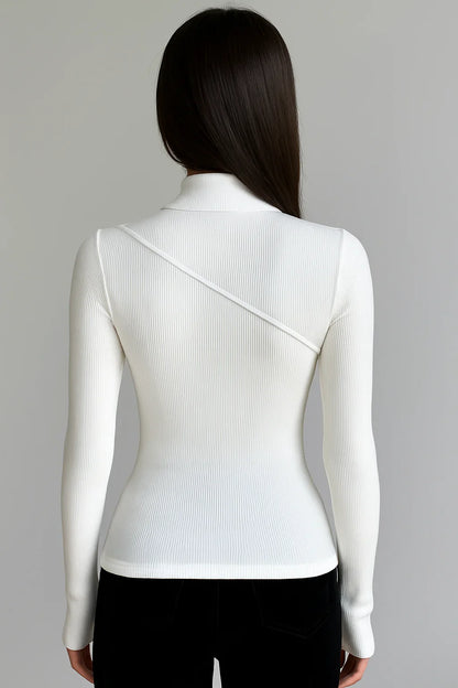 Haut femme blanche col montant, manches longues et tissu extensible pour un confort et une liberté de mouvement.