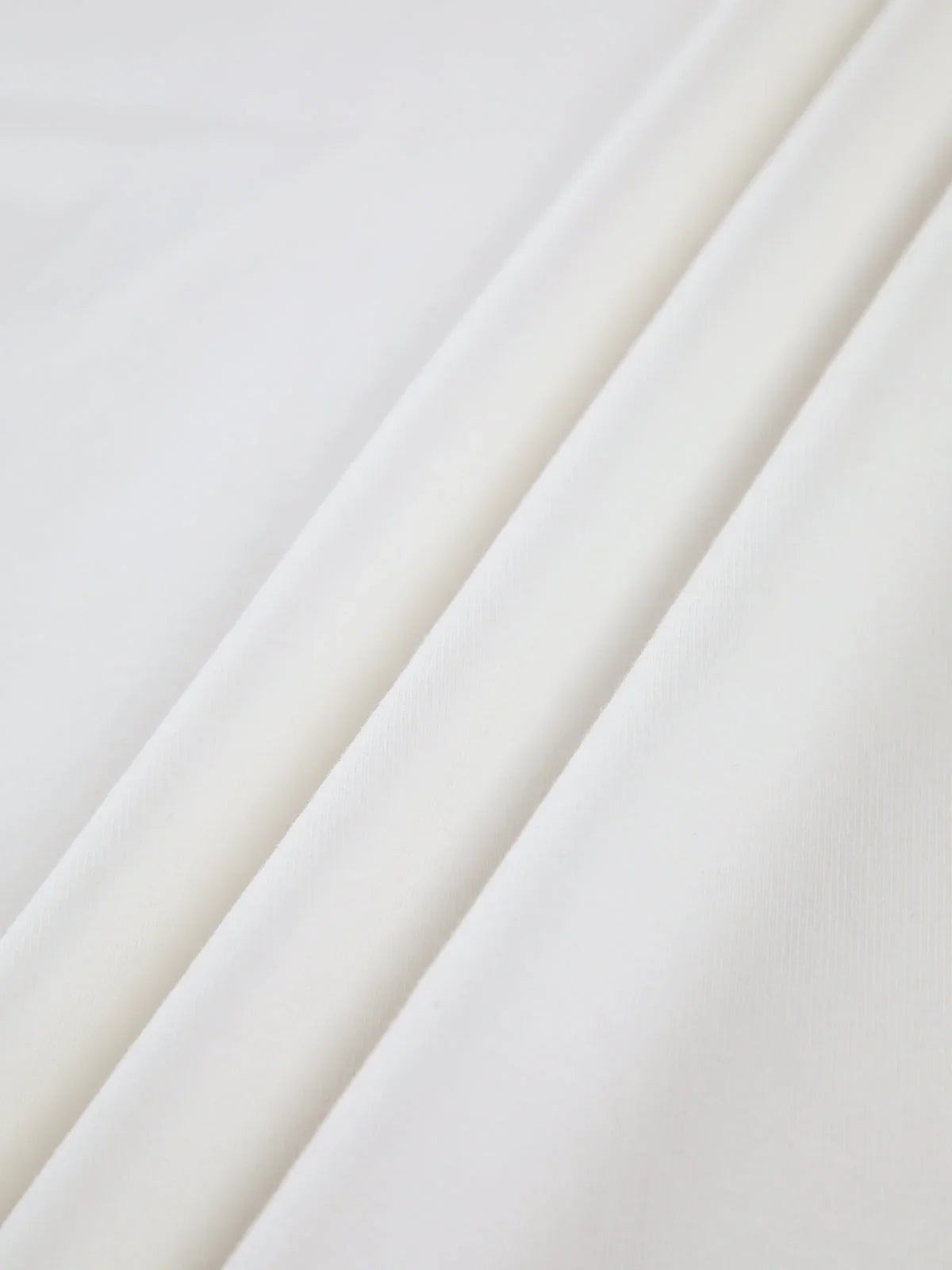 Haut femme blanc col montant, manches longues, en tissu extensible, idéal pour des tenues variées.