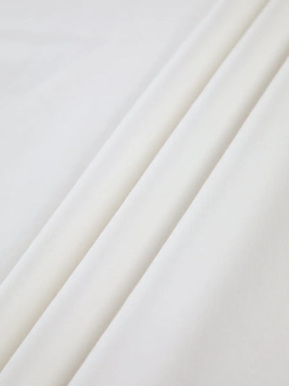 Haut femme blanc col montant, manches longues, en tissu extensible, idéal pour des tenues variées.